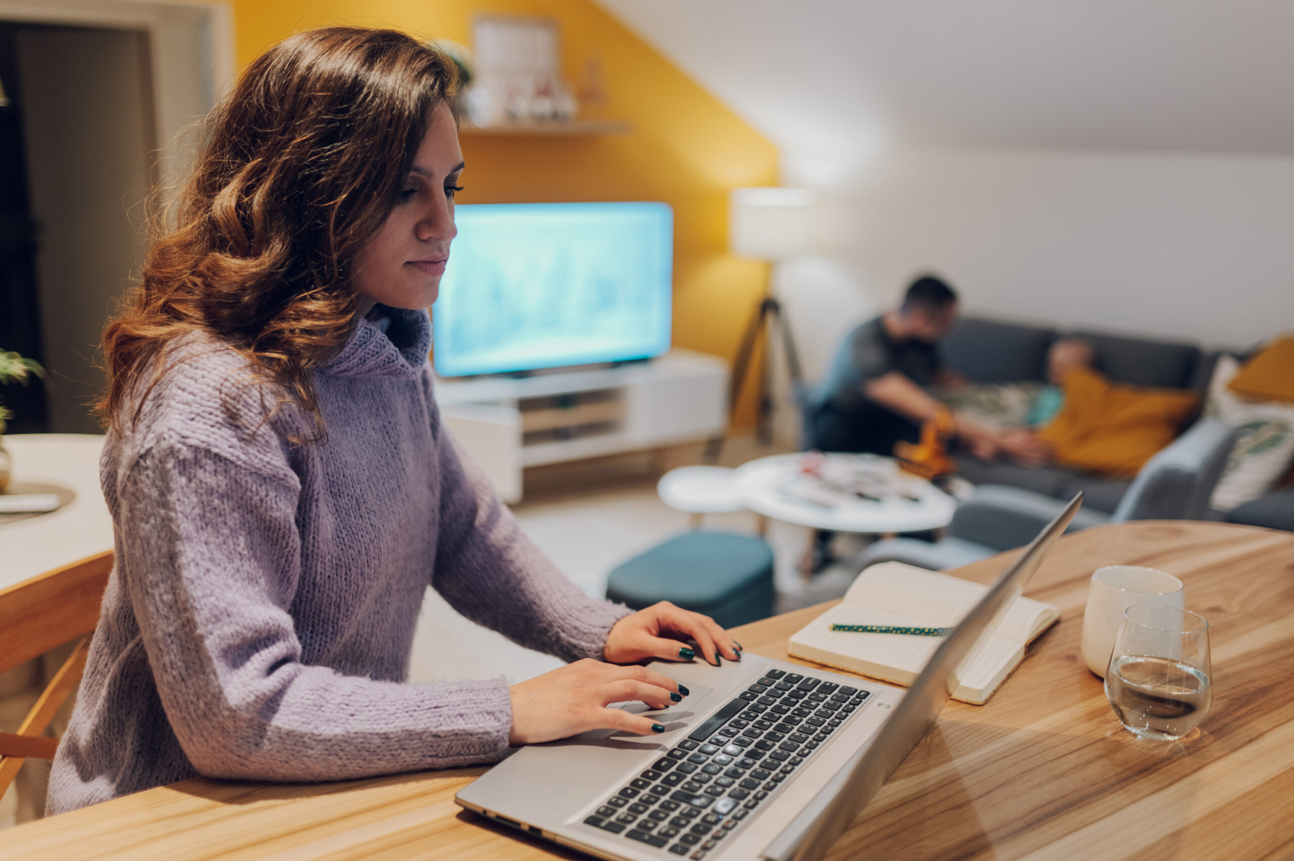 Hispanic businesswoman working from home on her laptop sitting in the kitchen