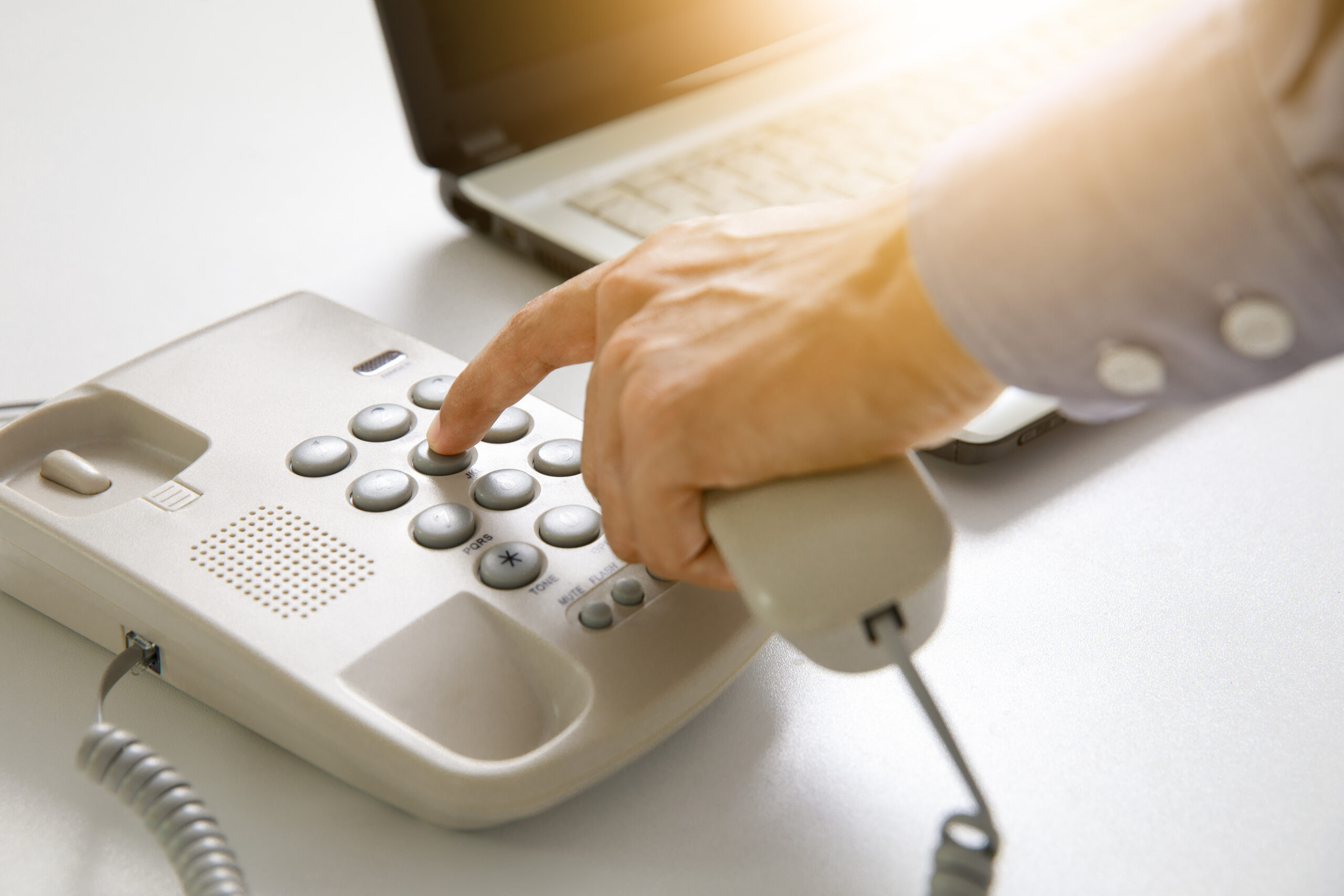 businessman dial digital telephone with office background